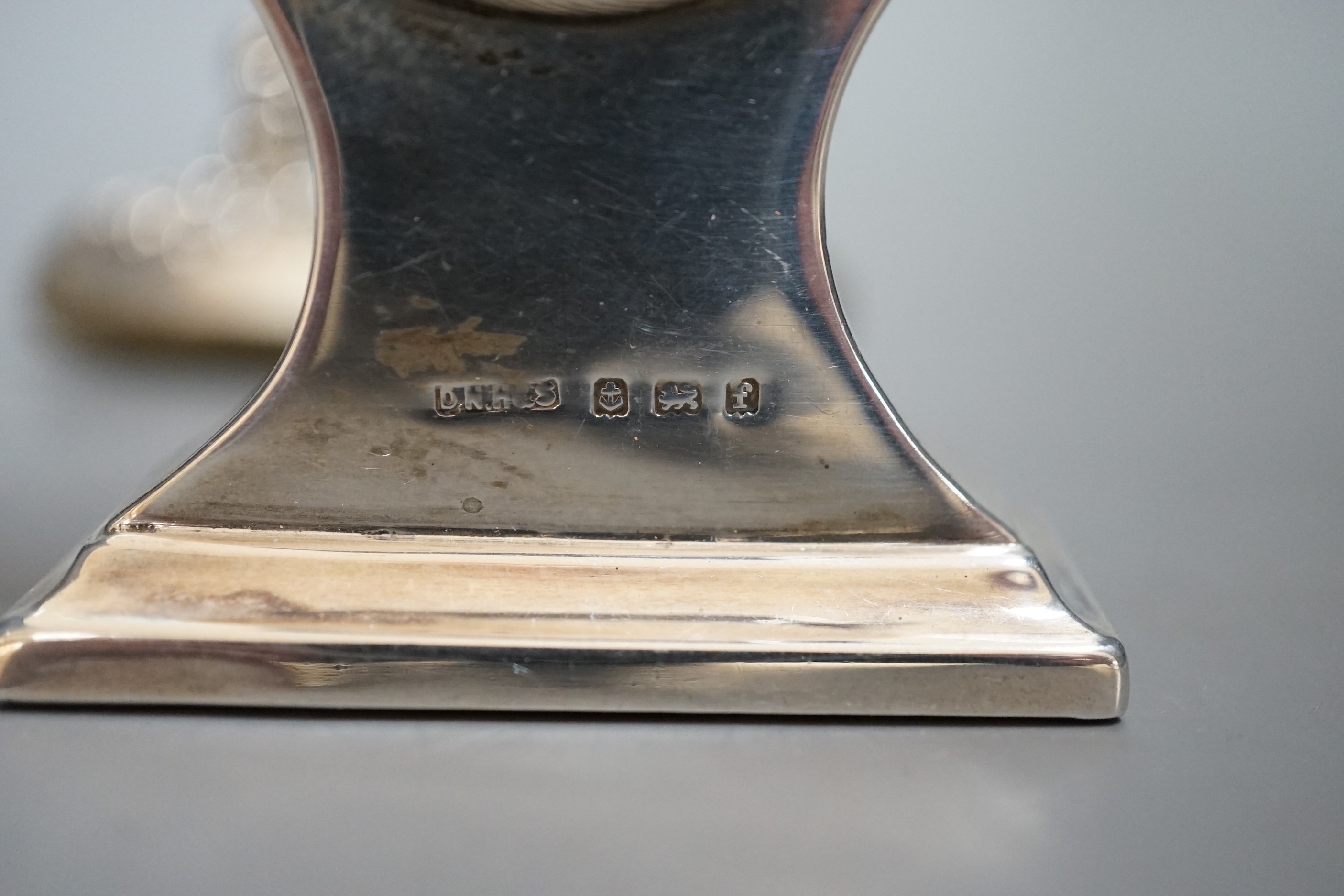 An Edwardian miniature silver-cased mantel timepiece, snuff box, blotter, clover-shaped dish and silver-capped glass jar.